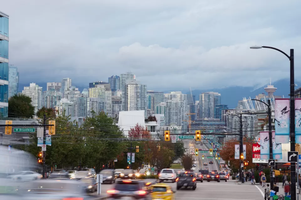 View of downtown Vancouver, British Columbia from middle of road busy with cars and buses
